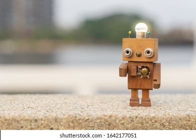 Retro wood robot with light bulb on the head standing on the table with blur nature background, nature and energy concepts. - Powered by Shutterstock - Get 15% off with code: PIKWIZARD15