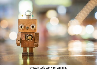 Retro wood robot with light bulb on the head standing on the table with bokeh light background, nature and energy concepts. - Powered by Shutterstock - Get 15% off with code: PIKWIZARD15