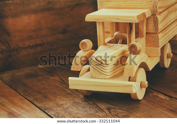 retro wooden toy\
car over wooden table. room for text. nostalgia and simplicity\
concept. retro style image\
