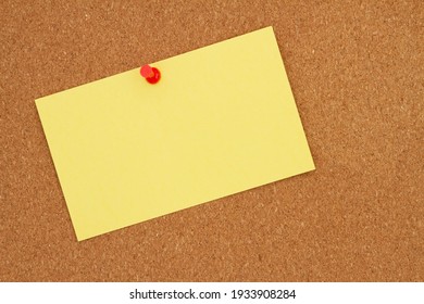 Retro Yellow Paper Index Card With Pushpin On Corkboard With Copy Space For Your Message