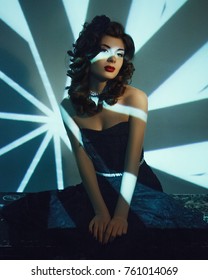 Retro-fashioned model is posing in artistic lights