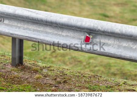 Retroreflector, warning optical unit is on a metal guardrail. Highway safety equipment, close-up