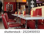 Retro-style diner with classic red and yellow dining booth, condiment bottles, and vintage decor creating nostalgic ambiance reminiscent of mid-20th century American diners