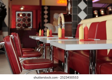 Retro-style diner with classic red and yellow dining booth, condiment bottles, and vintage decor creating nostalgic ambiance reminiscent of mid-20th century American diners