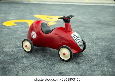 Retro-style toy car on the playground. Retro-style beige toy car. Stylish toy for a toddler boy