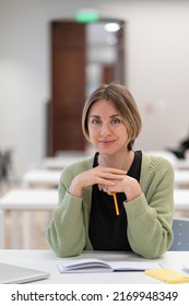 Returning To University As Mature Student. Happy Female Adult Learner Smiling At Camera While Studying In Classroom, Middle-aged Woman Getting Second Higher Education, Attending Educational Courses