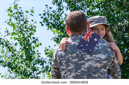 Reunion Of Soldier From Australia With Family, Daughter Hug Father. A Girl Holds The Flag Of Australia In Her Hand