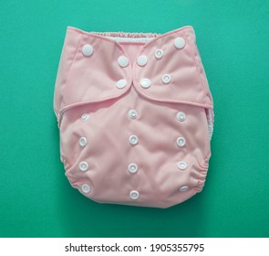 Reusable Baby Diaper. Eco Friendly Cloth Nappy Pink Color On Green Background. Sustainable Lifestyle, Zero Waste Concept.