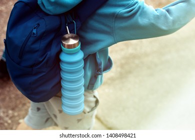 Reusable Blue Eco Friendly Water Bottle On Child's Backpack.