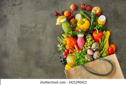 Reusable canvas grocery grocery bag with vegetables and fruits over dark grey scratched up background - Powered by Shutterstock