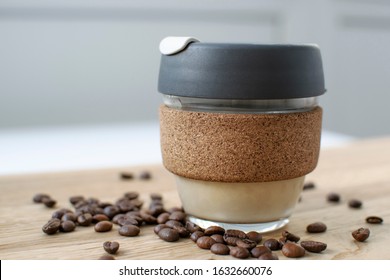 Reusable Coffee Eco Cup. Toughened Glass Cup & Natural Cork Band. Secure Silicon Lid. Reusable Eco Cup On A Wooden Background.Eco-Friendly, Spill Proof Travel Mug With Lid | Black. Keep Cup