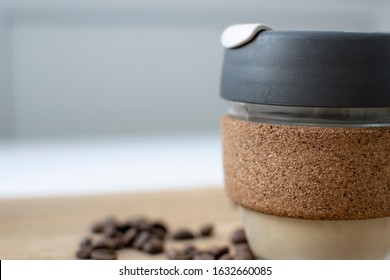 Reusable Coffee Eco Cup. Toughened Glass Cup & Natural Cork Band. Secure Silicon Lid. Reusable Eco Cup On A Wooden Background.Eco-Friendly, Spill Proof Travel Mug With Lid | Black. Keep Cup