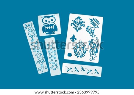 Reusable flexible plastic stencils for graphical design on a blue background