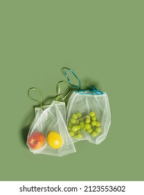 Reusable Grocery Bags From Net With Fruits, Reusable Packaging For Fruits And Vegetables, Eco Mesh Bag With Ribbon Ties, Eco Friendly And Zero Waste Concept, Above Olive Color Background, Top View