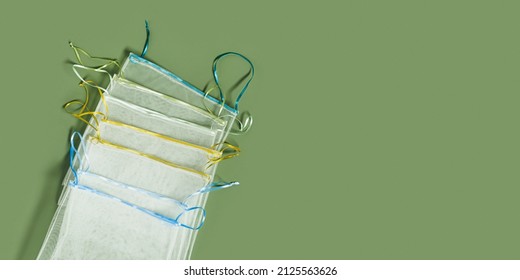 Reusable Grocery Bags From Net, Reusable Packaging For Fruits And Vegetables, Set Eco Mesh Bag With Colored Ribbon Ties, Eco Friendly And Zero Waste Concept, Above Olive Color Background, Top View