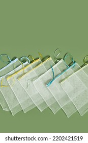 Reusable Grocery Bags From Net, Reusable Packaging For Fruits And Vegetables, Set Eco Mesh Bag With Colored Ribbon Ties, Eco Friendly And Zero Waste Concept, Above Olive Color Background, Top View