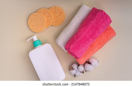 Reusable Make-up Remover Pad And Cleansing Product In White Bottle With Dispenser. Natural Cotton Balls, Multicolor Towels. Reusable Products For Bathroom And Skin Care.