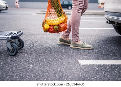 Reusable Mesh Bag With Groceries Purchased. Woman Standing At Parking Lot After Plastic Free Shopping At Supermarket. Ethical Consumerism And Sustainable Lifestyle With Zero Waste