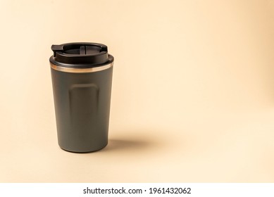 Reusable Mug, Plastic Travel Coffee Mug To Go. Plastic Mug With Silicone Holder On Natural Shade Beige Background.