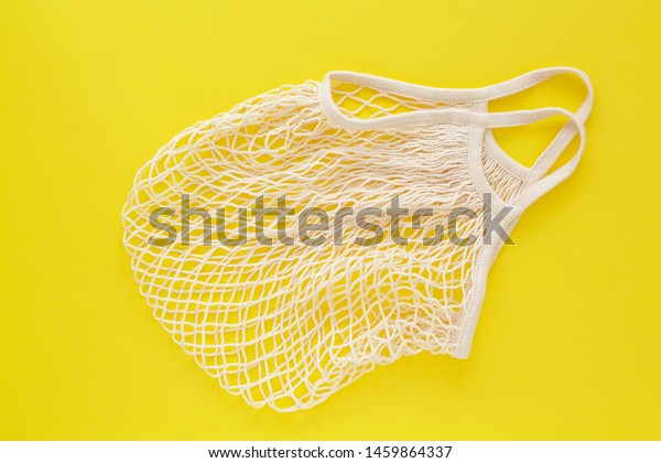 Reusable shopping bag on color
background. Ecological concept. Top view of mesh shopping cotton
bag. Caring for the environment and the rejection of plastic.
