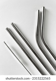 reusable stainless steel straws and cleaning brush in gray bag on white background, eco friendly lifestyle - Shutterstock ID 2315222565