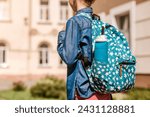 Reusable Water Bottle in School Backpack in Child Schoolgirl on School Background. Modern Blue Collapsible Silicone Bottle in Bag
