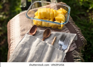 Reusable Wooden Cutlery In Carrying Pouch And Pineapple In A Glass Lunch Box.