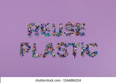 Reuse Plastic Text Consisting Of Small Recycled Plastic Pellets Collected From The Sea Water. Rethinking The Environment By Reducing Or Reusing Plastics. Circular Economy Concept. Flatlay, Lila Purple