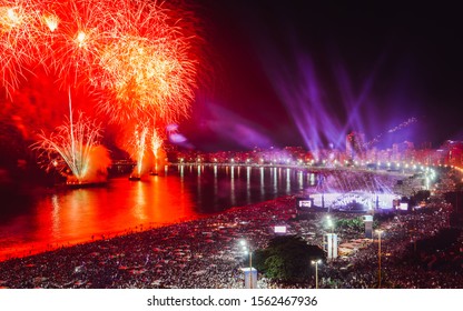 Revellers, both locals and tourist, enjoy the breath-taking New Years fireworks display along Copacabana Beach, Rio de Janeiro, Brazil. The largest party in the world. Long exposure deliberate blur