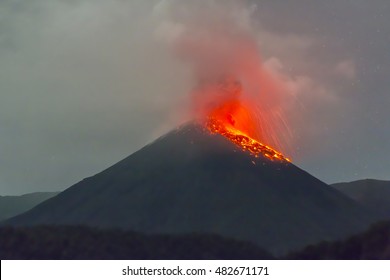 Reventador Volcano, Ecuador erupting at night, November 2015. Red hot rocks and gas are thrown out of the crater. Reventador rises out of tropical rainforest in the Ecuadorian Amazon.