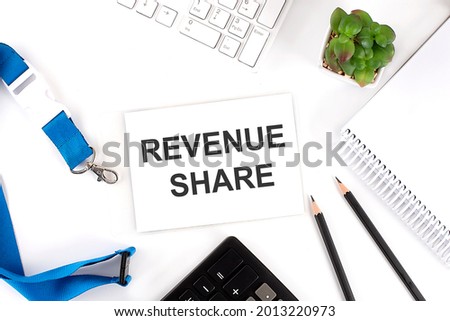 REVENUE SHARE Words on card with keyboard and office tools