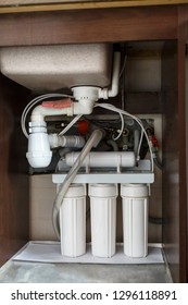 Reverse Osmosis Water Purification System At Home. Installation Of Water Purification Filters Under Kitchen Sink In Cupboard. Clear Water Concept