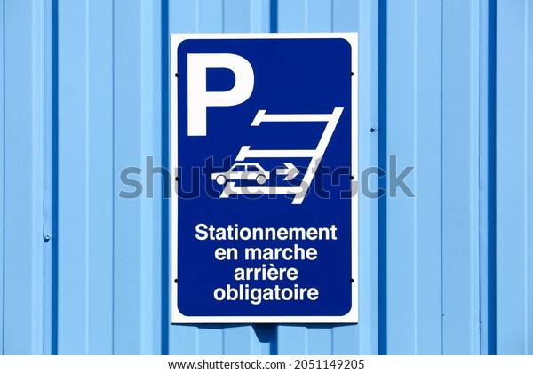Reverse parking only sign\
on a wall called stationnement en marche arriere obligatoire in\
french language