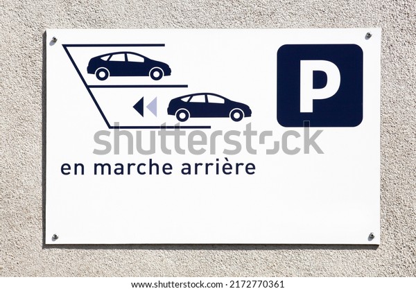Reverse parking only sign on a wall\
called stationner en marche arriere in french language\
