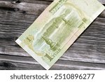 reverse side of 1 one Chinese Yuan cash money bill banknote features The Three Pools Mirroring the Moon depicting lanterns in water on West Lake in Hangzhou City, Zhejiang province, selective focus