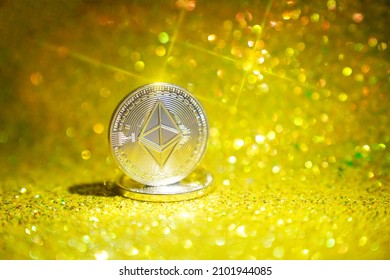 The reverse side is ether. Cryptocurrency ether is the coin of the future. Golden ether. Golden shiny background. High quality photo