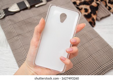 The reverse side of a marble case for a smartphone close-up on a wooden background
