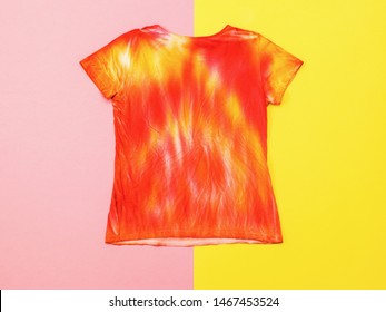 The reverse side of the t-shirt in the style of tie dye on a two-tone background. Staining fabric in tie dye style. Flat lay.