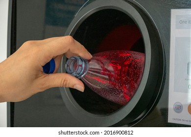 Reverse Vending Machine. Woman Hand Put Empty Plastic Bottle In The Machine. Reverse Vending Machine For Refund And Recycling Metal Drink Cans, Plastic And Glass Bottles
