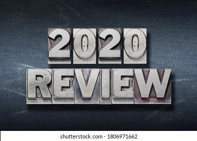 review 2020 phrase made from metallic letterpress on dark jeans background