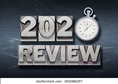 review 2020 phrase made from metallic letterpress with stopwatch