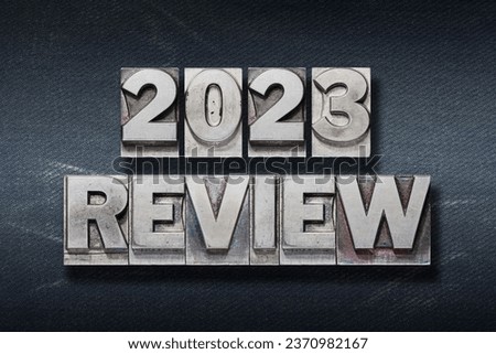 review 2023 phrase made from metallic letterpress on dark background