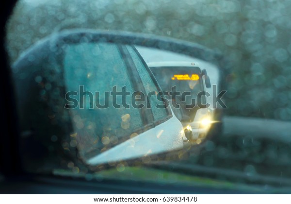 review mirror of the car in rain. ? dangerous move,\
emergency dusk