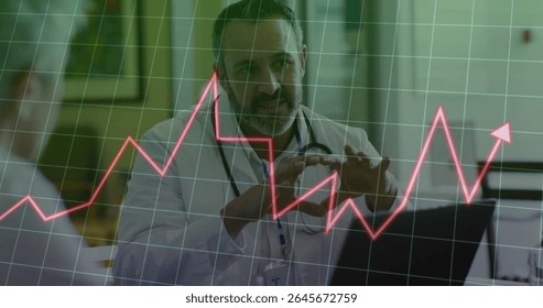Reviewing doctor in white coat analyzing red data chart on laptop in clinic, with stethoscope. Medical, healthcare, analysis, professional, technology, diagnostics, clinical