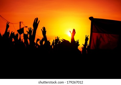 Revolution, people protest against government, man fighting for rights, silhouettes of hands up in the sky, threat of war 