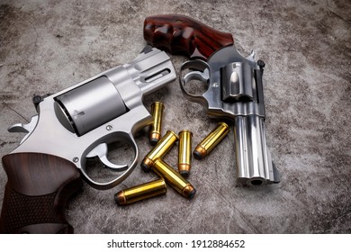 Revolver Pistol Hand Guns With Bullets On Cement Texture Background