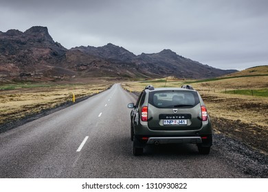 Reykjanes Peninsula, Iceland - June 13, 2016: Car On The Straight Asphalt Road Among Rocky Volcanic Landscape On A Cloudy Summer Day