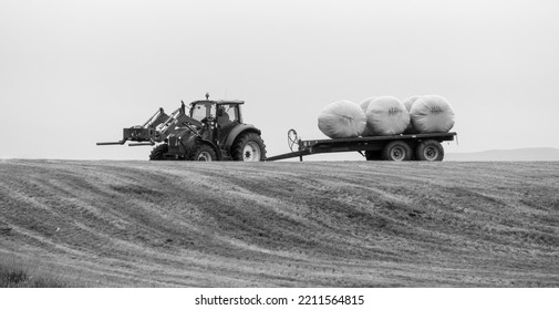 Reykjavik, Iceland - August 1 2021: Icelandic Farmer Moving Some Hay Bales On A Tractor