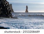 Reynisfjara black sand beach in Iceland. Ocean cliffs. Sunny day. Seascape. Touristic place.