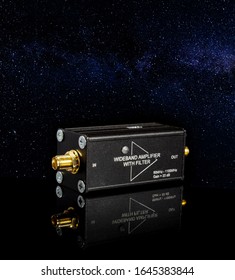 RF And Microwave Wideband Signal Amplifier Isolated On The Black Reflective Surface Over The Starry Night Background